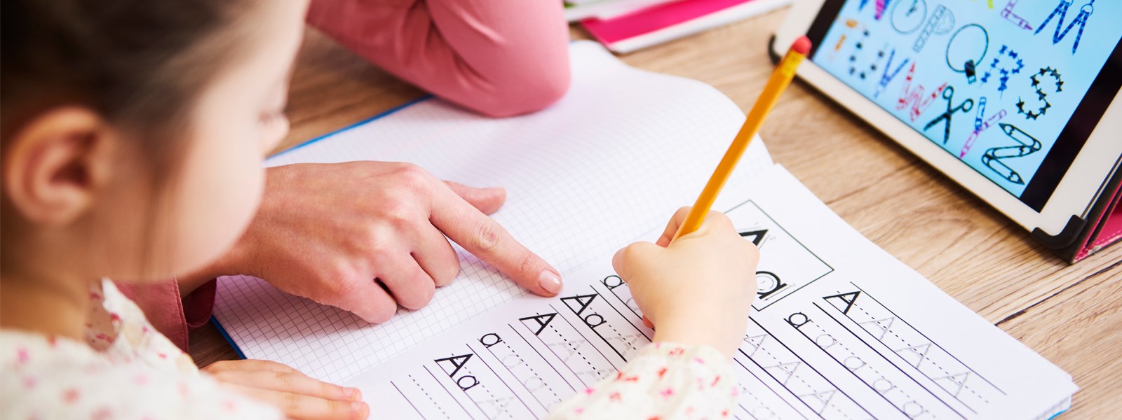 girl practicing writing her letters